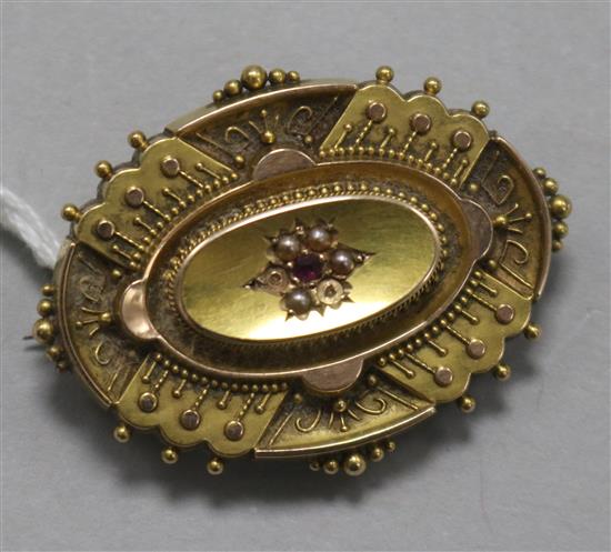 A late Victorian 15ct gold, ruby and seed pearl oval brooch, (2 seed pearls missing) 39mm.